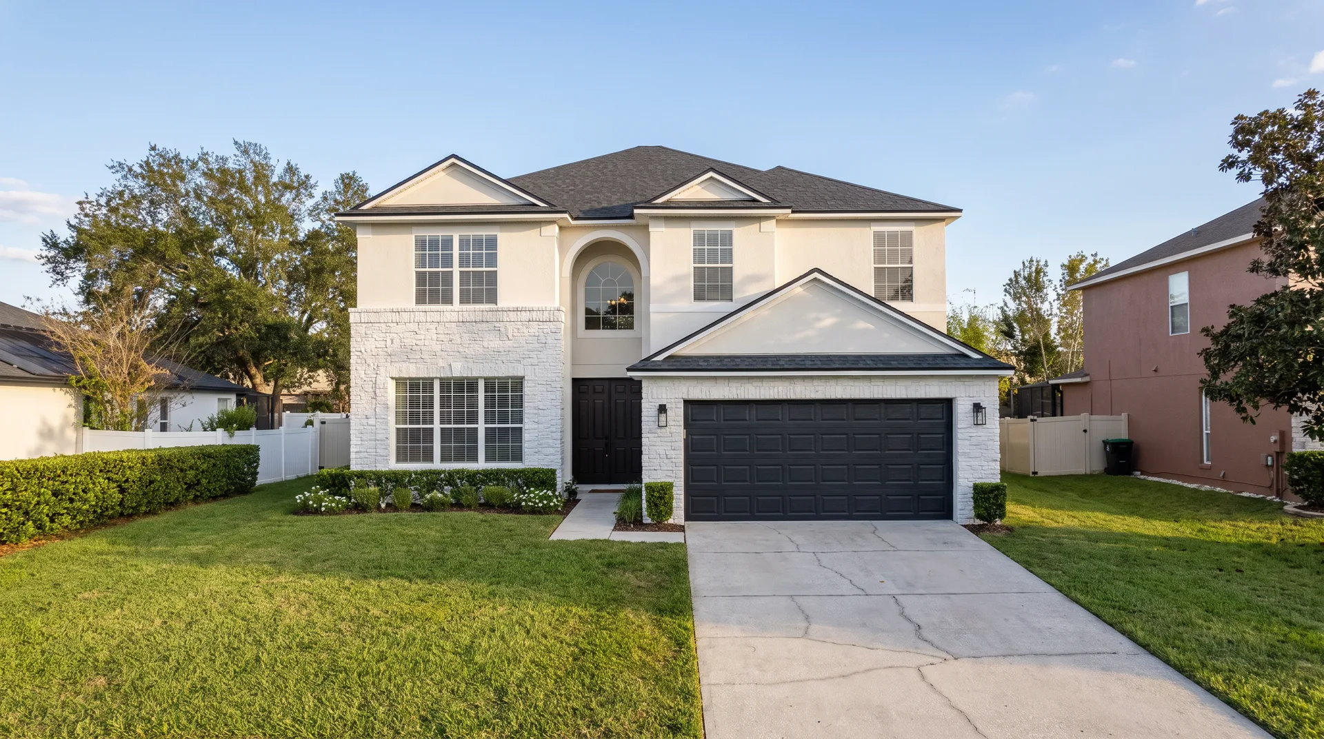AI-assisted concept vision: the same front exterior with warm-white stucco, white painted stone, and dark garage and entry doors.