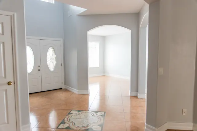Current condition entry with double leaded-glass front doors and tile floor medallion.